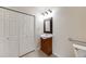 Bathroom with a closet and a wooden vanity with a decorative mirror and modern lighting at 22813 E Briarwood Pl, Aurora, CO 80016