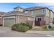 Home exterior with green siding, stone accents, a two-car garage and well maintained landscaping at 22813 E Briarwood Pl, Aurora, CO 80016