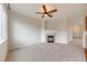 Cozy living room featuring a fireplace, neutral carpet, ceiling fan and ample natural light at 22813 E Briarwood Pl, Aurora, CO 80016