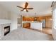 Open floor plan with fireplace, carpeted living room, ceiling fan, and updated kitchen at 22813 E Briarwood Pl, Aurora, CO 80016