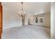 Bright living room with large chandelier, neutral carpet, and staircase access at 22813 E Briarwood Pl, Aurora, CO 80016