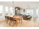 Modern dining room adjacent to kitchen, featuring hardwood floors and large windows at 4222 Stuart St, Denver, CO 80212