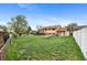 Large, green backyard enclosed with a white vinyl fence and patio area at 1549 Dean Dr, Northglenn, CO 80233