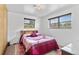 A bedroom with two windows, a patterned rug, and a wooden headboard at 1549 Dean Dr, Northglenn, CO 80233