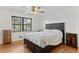 Bright bedroom with hardwood floors, ceiling fan, and ample natural light from large window at 1549 Dean Dr, Northglenn, CO 80233