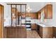 Cozy kitchen with wooden cabinets, white countertops, and a breakfast bar with hanging fruit baskets at 1549 Dean Dr, Northglenn, CO 80233