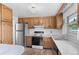 Traditional kitchen features wooden cabinets, white countertops, and stainless steel refrigerator at 1549 Dean Dr, Northglenn, CO 80233