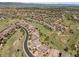 Sweeping aerial view shows a sprawling community of homes among green hills at 10757 Timberdash Ave, Highlands Ranch, CO 80126