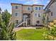 Large backyard with green lawn, a fire pit, mature trees, and a second story deck at 10757 Timberdash Ave, Highlands Ranch, CO 80126