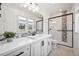 Bright bathroom with white cabinets, black hardware and a decorative tiled shower at 10757 Timberdash Ave, Highlands Ranch, CO 80126