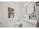 Bright bathroom with modern vanity, marble-style wall, and a window offering natural light at 10757 Timberdash Ave, Highlands Ranch, CO 80126