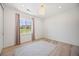Bright bedroom featuring light wood floors, neutral colored curtain and an eye-catching rug at 10757 Timberdash Ave, Highlands Ranch, CO 80126