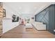 Open-concept living room showcasing recessed lights, modern sectional sofa, blue accent wall, hardwood floors, and tv at 10757 Timberdash Ave, Highlands Ranch, CO 80126