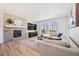 Bright living room features a cozy fireplace and large windows with scenic outdoor views at 10757 Timberdash Ave, Highlands Ranch, CO 80126