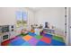 Colorful playroom with soft flooring, natural light, and ample space for activities at 10757 Timberdash Ave, Highlands Ranch, CO 80126