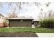 An expansive backyard featuring a charming green brick house, healthy lawn, and mulch landscaping at 1330 Olive St, Denver, CO 80220