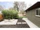 A cozy backyard featuring a fire pit with adirondacks and lush landscaping near a green brick house at 1330 Olive St, Denver, CO 80220