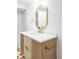 Stylish bathroom vanity with wood drawers, bright lighting, and gold-framed mirror at 1330 Olive St, Denver, CO 80220