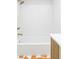 Bright bathtub and shower featuring white subway tile and bronze fixtures at 1330 Olive St, Denver, CO 80220