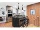 Stylish kitchen with modern appliances, a black island, and wood cabinets at 1330 Olive St, Denver, CO 80220