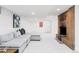 Spacious living room with brick fireplace and soft gray sectional sofa and white walls at 1330 Olive St, Denver, CO 80220