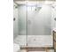 Modern shower with glass door, rain shower head, and unique tile flooring at 1330 Olive St, Denver, CO 80220