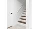 Clean, white staircase featuring brown wood steps, white risers, and a simple handrail at 1330 Olive St, Denver, CO 80220