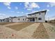 Backyard view of a two-story home with gray siding and patio overlooking the yard at 24790 E 39Th Ave, Aurora, CO 80019