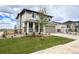 Attractive two-story home featuring a lush green lawn, young tree, and inviting curb appeal at 24790 E 39Th Ave, Aurora, CO 80019