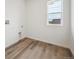 Empty laundry room with luxury vinyl flooring, utility sink and window at 24790 E 39Th Ave, Aurora, CO 80019