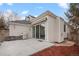 An outdoor grill awaits on the concrete patio of this home with a door leading inside and manicured landscaping at 1011 S Valentia St # 3, Denver, CO 80247