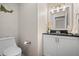 Cozy powder room with white cabinets, black countertop, and modern light fixture at 1011 S Valentia St # 3, Denver, CO 80247