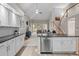 Bright kitchen with white cabinets, black countertops, and an open view of the living area at 1011 S Valentia St # 3, Denver, CO 80247