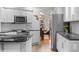Well-lit kitchen featuring white cabinets, stainless steel appliances, and granite countertops with a view into dining nook at 1011 S Valentia St # 3, Denver, CO 80247