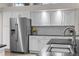 Bright kitchen with a stainless steel refrigerator, white cabinetry, granite countertops and modern fixtures at 1011 S Valentia St # 3, Denver, CO 80247