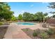 A community pool is surrounded by lounge chairs, tables and a brick wall in this image at 1011 S Valentia St # 3, Denver, CO 80247