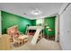 This playroom features green walls, carpet, and an indoor slide and trampoline at 4782 S Xenia St, Denver, CO 80237