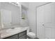 Bright bathroom features a window, a white toilet, and a vanity with a gray cabinet at 9080 Gale Blvd # 4, Thornton, CO 80260