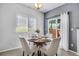 Bright dining area features a modern light fixture, window, and access to the fenced backyard at 9080 Gale Blvd # 4, Thornton, CO 80260