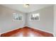 This bedroom features neutral walls, two bright windows, and natural wood floors at 3031 W 20Th Ave, Denver, CO 80211