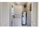 Compact laundry area with a stackable washer and dryer, plus a water heater at 3031 W 20Th Ave, Denver, CO 80211