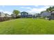 Spacious backyard featuring a large, lush lawn, mature trees, and outdoor entertaining area at 4879 S Johnson St, Littleton, CO 80123