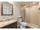 Bathroom featuring a vanity, toilet, and tiled shower with a rainfall shower head at 4879 S Johnson St, Littleton, CO 80123