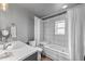 Bathroom with white tiled shower and tub, white vanity, and neutral walls at 4879 S Johnson St, Littleton, CO 80123
