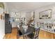 Open-concept dining area with hardwood floors, leads to stairs, fireplace, and modern kitchen at 4879 S Johnson St, Littleton, CO 80123
