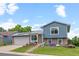 Charming two-story home with blue siding, brick accents, solar panels, and well maintained front yard landscaping at 4879 S Johnson St, Littleton, CO 80123