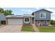 Charming two-story home with blue siding, brick accents, and a well-manicured lawn and front yard landscaping at 4879 S Johnson St, Littleton, CO 80123