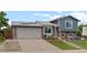 Charming home with brick and siding, a two-car garage, a seating area and well-maintained landscaping at 4879 S Johnson St, Littleton, CO 80123