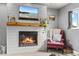 Close up on the living area fireplace with mounted tv and cozy accent chair at 4879 S Johnson St, Littleton, CO 80123