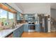 Modern kitchen featuring blue cabinets, stainless steel appliances, and stylish backsplash with an eat-in area at 4879 S Johnson St, Littleton, CO 80123